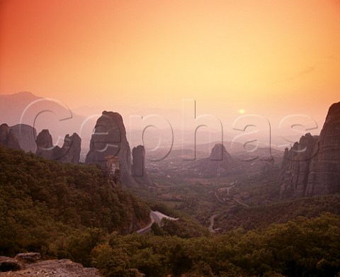 Dusk falls over Roussano Monastery amidst the rock pinnacles of the Meteora with the Plain of Thessaly beyond   Greece