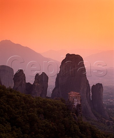 Dusk falls over Roussano Monastery amidst the rock   pinnacles of the Meteora  the Plain of Thessaly   lies beyond Greece