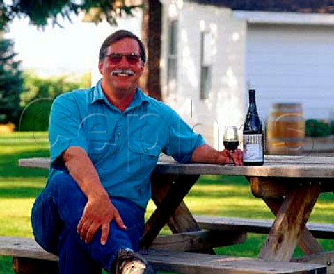 Clay Mackey coowner and viticulturist of   Chinook Wines with a bottle of his Cabernet Franc in   the garden by his tasting room   Prosser Washington USA   Yakima Valley AVA