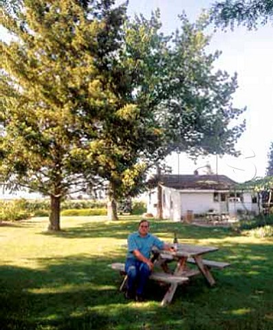 Clay Mackey coowner and viticulturist of   Chinook Wines with a bottle of his Cabernet Franc in   the garden by his tasting room   Prosser Washington USA   Yakima Valley AVA