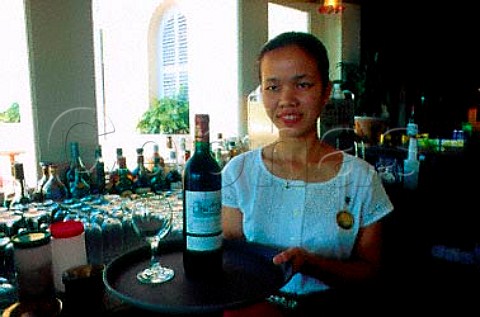 Waitress with bottle of Bordeaux wine in   a fivestar hotel near Angkor Wat   Cambodia