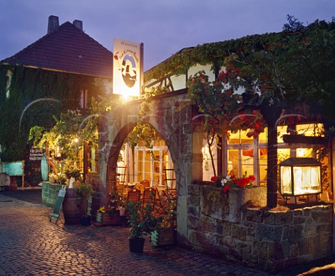 Entrance archway and illuminated terrace of a small weinstube  restaurant Zum Kleinen Prinz on the main street in Forst Pfalz Germany