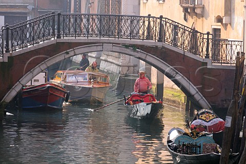 Boats and gondolas on canal Venice Italy