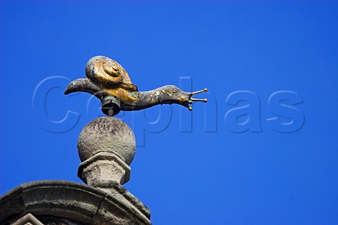 Statue of a snail on a rooftop spire in the centre   of Brugge Belgium