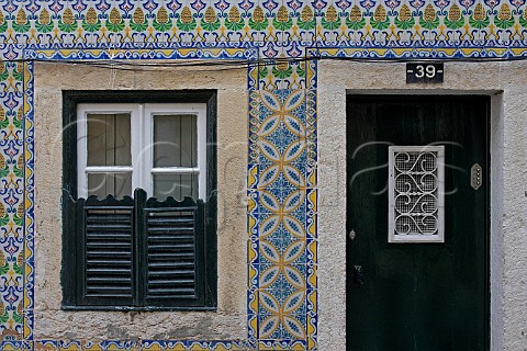 Traditional azulejos tiles surrounding window and   doorway Alfama Old Lisbon Portugal