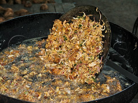 Frying onions for onion bhajis deepfried Chennai   Madras India