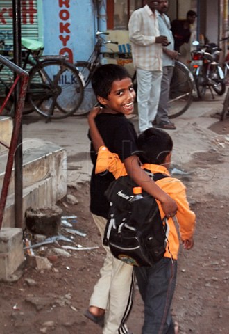 Two young Indian boys walking along the road   Chennai Madras India