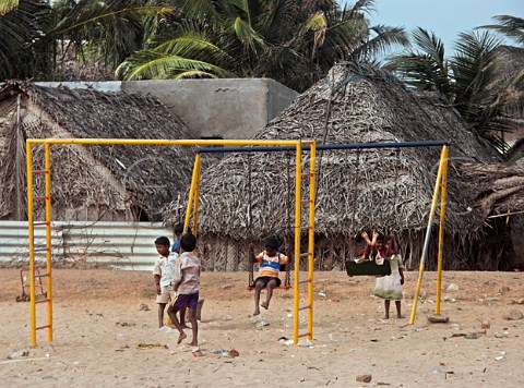 Children playing on swings on the beach Chennai   Madras India