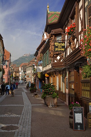 Main street in Ribeauvill with HautRibeaupierre   castle in the distance HautRhin France  Alsace