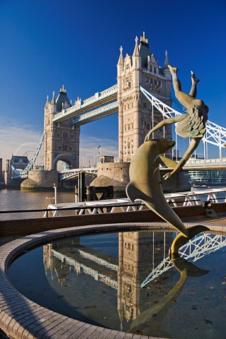 Sculpture of Girl and Dolphin fountain with Tower Bridge behind London