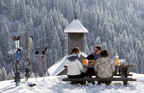 Skiers have lunch by the chapel on the Col des Annes in the Chaine des Aravis  Le GrandBornand HauteSavoie France