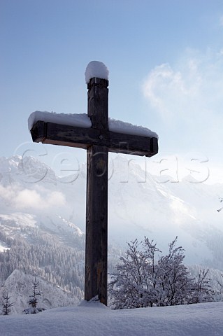 Cross by the road leading to the Col des Annes from Le GrandBornand with the Chaine des Aravis beyond HauteSavoie France