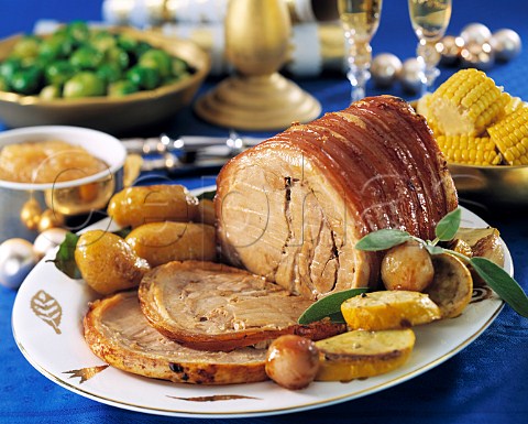 Roast Pork joint sliced with vegetables in a festive table setting
