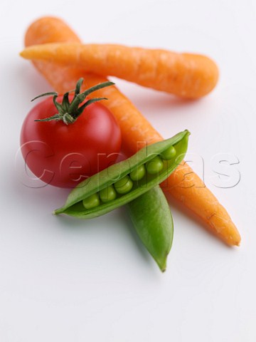Carrots peas in the pod and a tomato