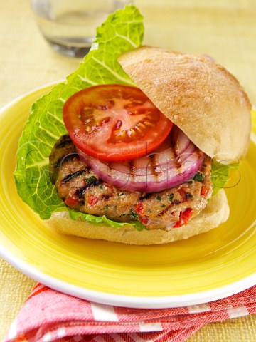 Chicken burger with salad and onion in a roll