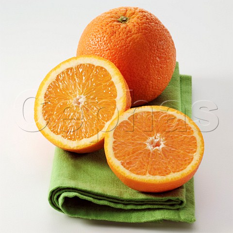 Whole and halved orange on a napkin