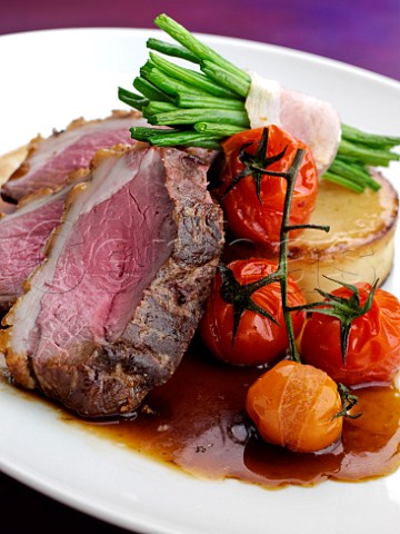 Plate of lamb rump with asparagus and vine tomatoes