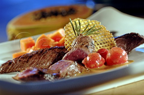 Beef steak with cherry tomatoes papaya cubes and papaya sauce