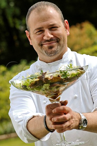 Chef holding glass comport with green and grape salad