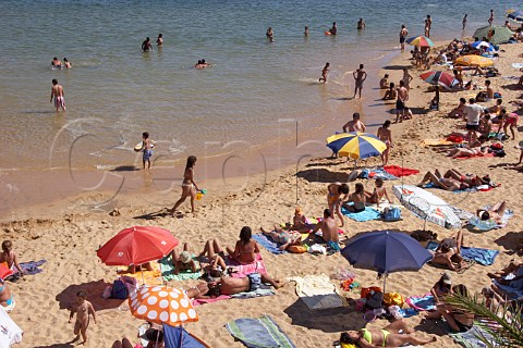 People sunbathing on the beach by the Mira River estuary at Vila Nova de Milfontes Odemira Portugal
