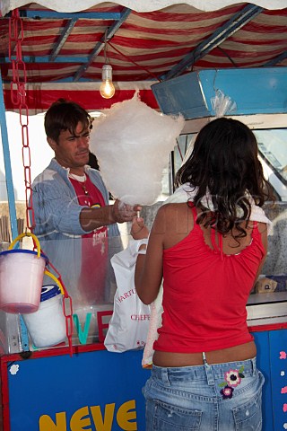 Girl buying candy floss on a stick at Almograve Odemira Portugal