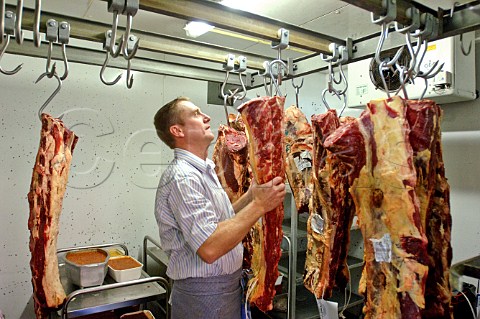 Sides of meat hanging in a cold store
