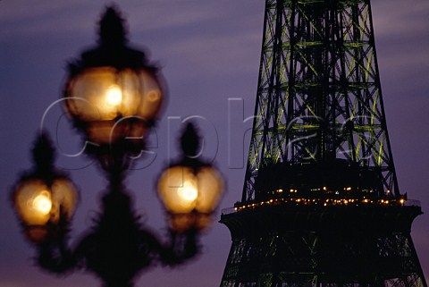 The ornate lamps of Pont Alexandre III with  the Eiffel Tower in the distance Paris France