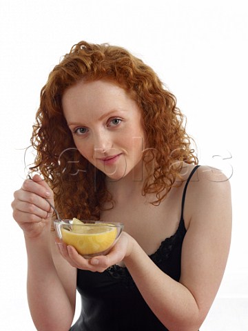 Young woman with half a grapefruit for breakfast