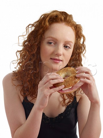 Young woman at breakfast bagel with ham and cream cheese