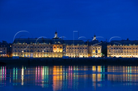 Street lights on the riverside promenade at Place de la Bourse reflecting in the Garonne river at night Bordeaux Gironde France