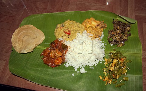Indian meal served on a banana leaf  Rice prawns pappadom North Kerala India