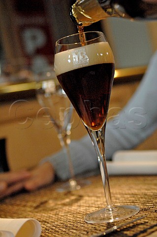 Pouring glass of dark Belgian beer