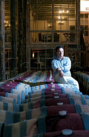 Mario Geisse winemaker for Casa Silva in barrel cellar of the San Fernando winery with the winery restaurant and wine bar behind Colchagua Valley Chile