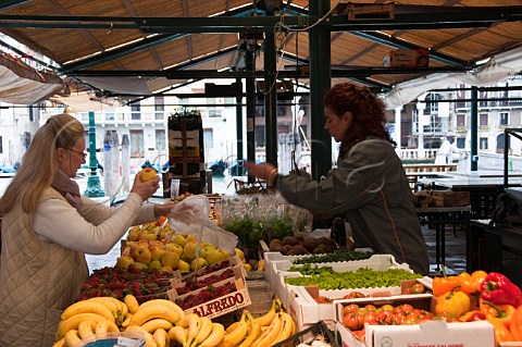 Woman buying apples Rialto market San Polo Venice Italy