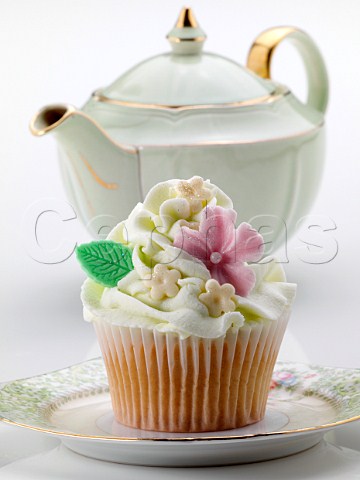 Flower iced cupcake and green teapot