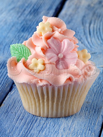 Flower iced cupcake on a blue background