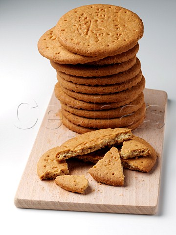 A stack of digestive biscuits on a wooden board