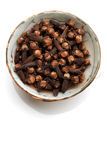 A bowl of cloves on a white background