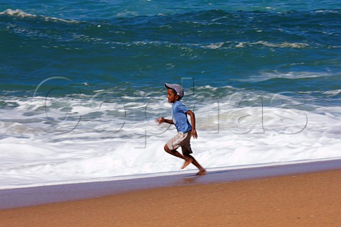 Young boy running along the beach at Amanzimtoti KwaZuluNatal South Africa