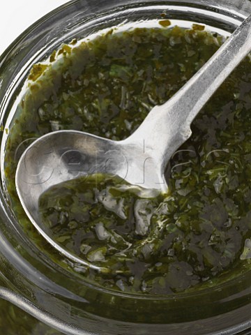 A jar of mint sauce with a spoon