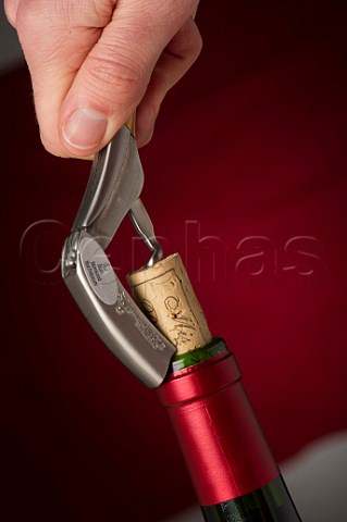 Removing the cork of a wine bottle with a Laguiole corkscrew