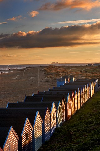 Beach huts at Southwold with Sizewell Nuclear Power Stations in distance Suffolk England