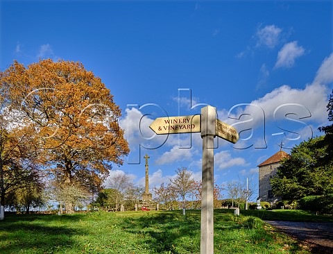 Signpost pointing to winery by the war memorial and church in Stopham Sussex England