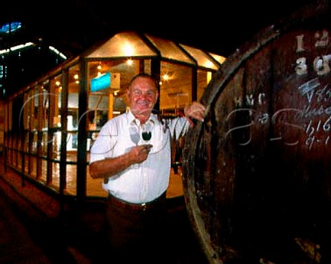 Mick Morris leans on a cask of his Liqueur Muscat   His new tasting room erected within the old   corrugated iron winery is behind him   Morris Wines Rutherglen Victoria Australia