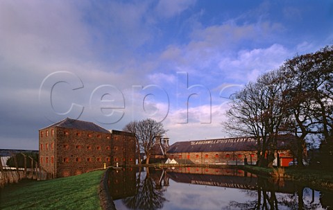 Old Bushmills Distillery viewed over the dammed St Columbs Rill the source of water for the whiskey   making Bushmills County Antrim Northern Ireland