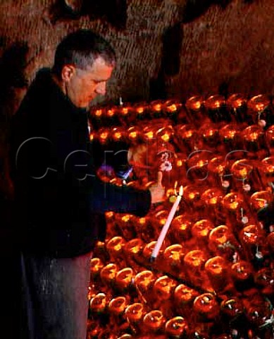 Checking the position of the sediment in bottles of   Belle Epoque Rose in the cellars of Champagne   PerrierJouet Epernay This is a vintage Champagne   in a distinctive enamelled bottle