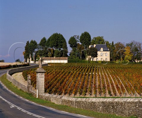 The D2 road snakes past a vineyard of Chteau Latour with Chteau PichonLonguevilleComtessedeLalande beyond The monuments in the wall signify the end of Chteau LovillelasCases vineyards in the commune of StJulien and the start of Latour in PauillacGironde France   Mdoc  Bordeaux