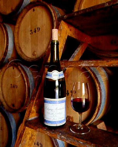 Bottle and glass of red Clos du Cailleret in the barrel chais of Chartron et Trebuchet PulignyMontrachet Cte dOr France Cte de Beaune Premier Cru