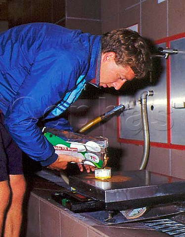 Winemaker weighing out tannin to add to a tank of   fermenting Merlot at the Union de Producteurs de   Rauzan Gironde France  Bordeaux  EntreDeuxMers