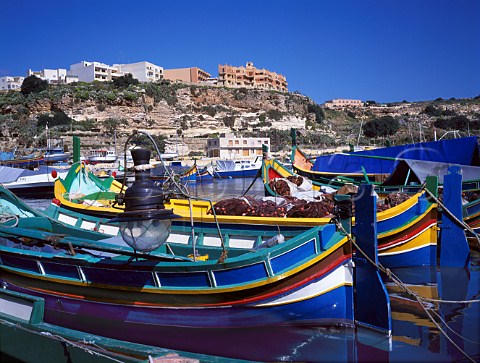 Fishing boats in Mgarr harbour with the LImgarr   Hotel on the cliff top Gozo Malta